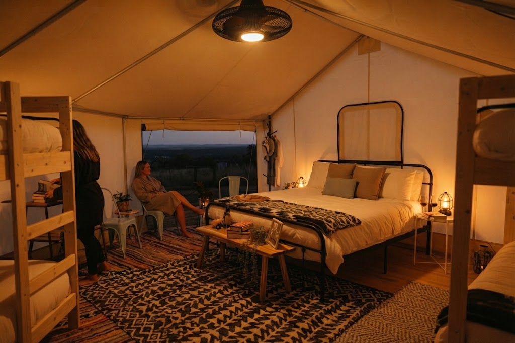 Glamping pod and hot tub lit at night with a clear starry sky above the surrounding Lake District fells