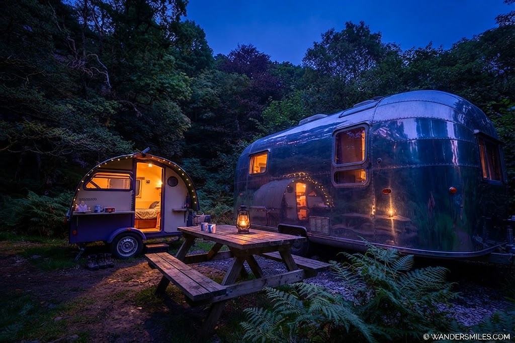 Luxury glamping pod with large glazed doors, decking and outdoor seating overlooking a Lake District valley